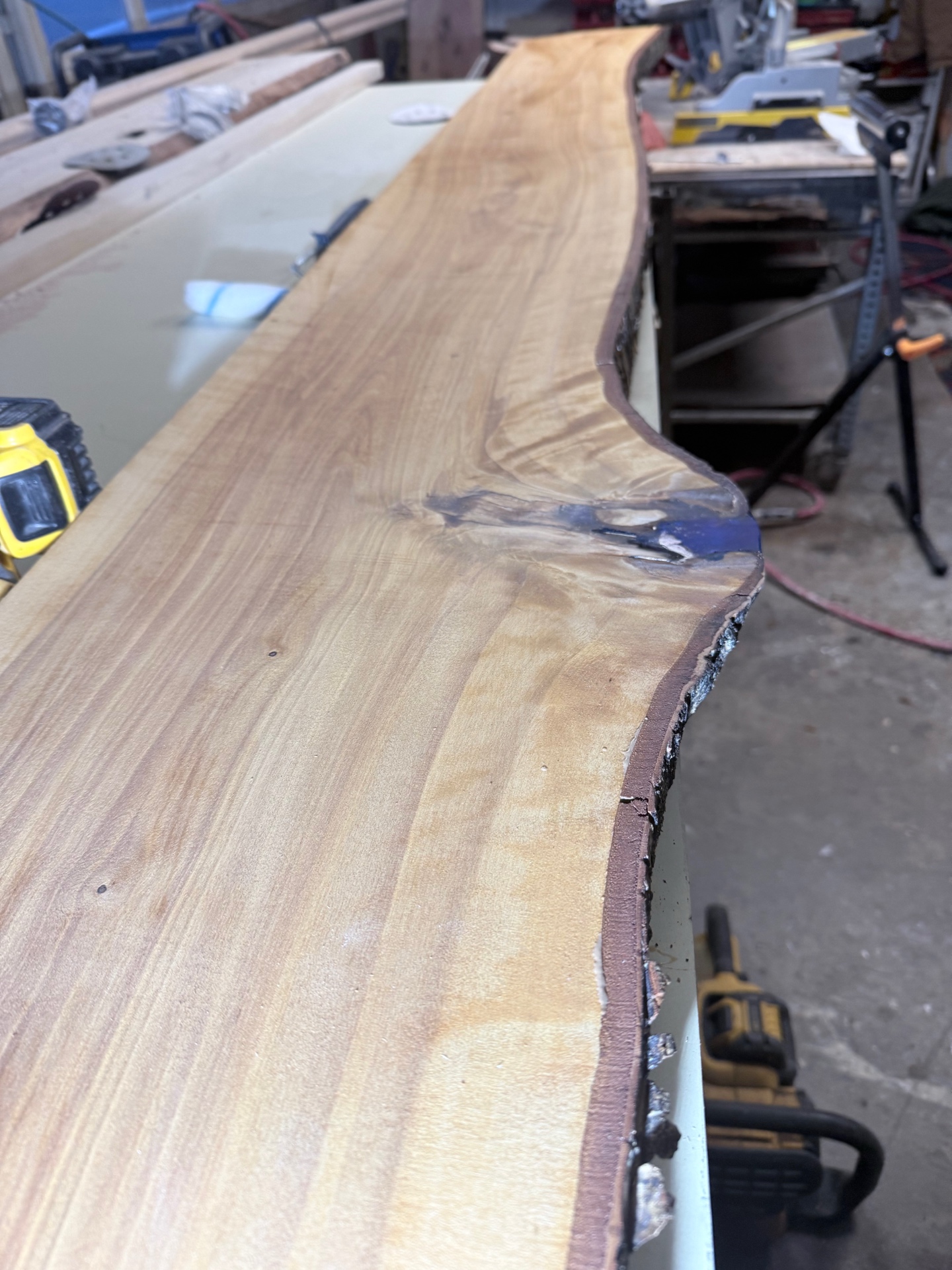 Live-edge wood slab being prepared in workshop